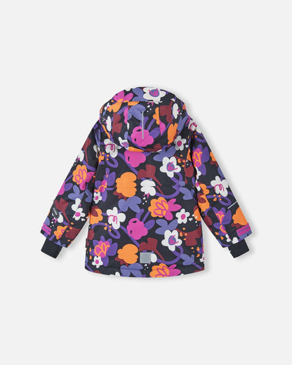 Back view of the Reima Kiiruna girls' winter ski jacket in the black floral print, showcasing the attached protective hood, seamless weather-resistant design, and a reflective safety patch at the bottom hem.