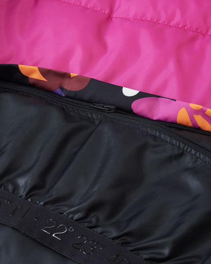 Interior detail of the Reima Kiiruna girls' ski jacket, showing the internal zipper mechanism that allows the waist snow lock powder skirt to be completely detached from the bright pink inner lining.