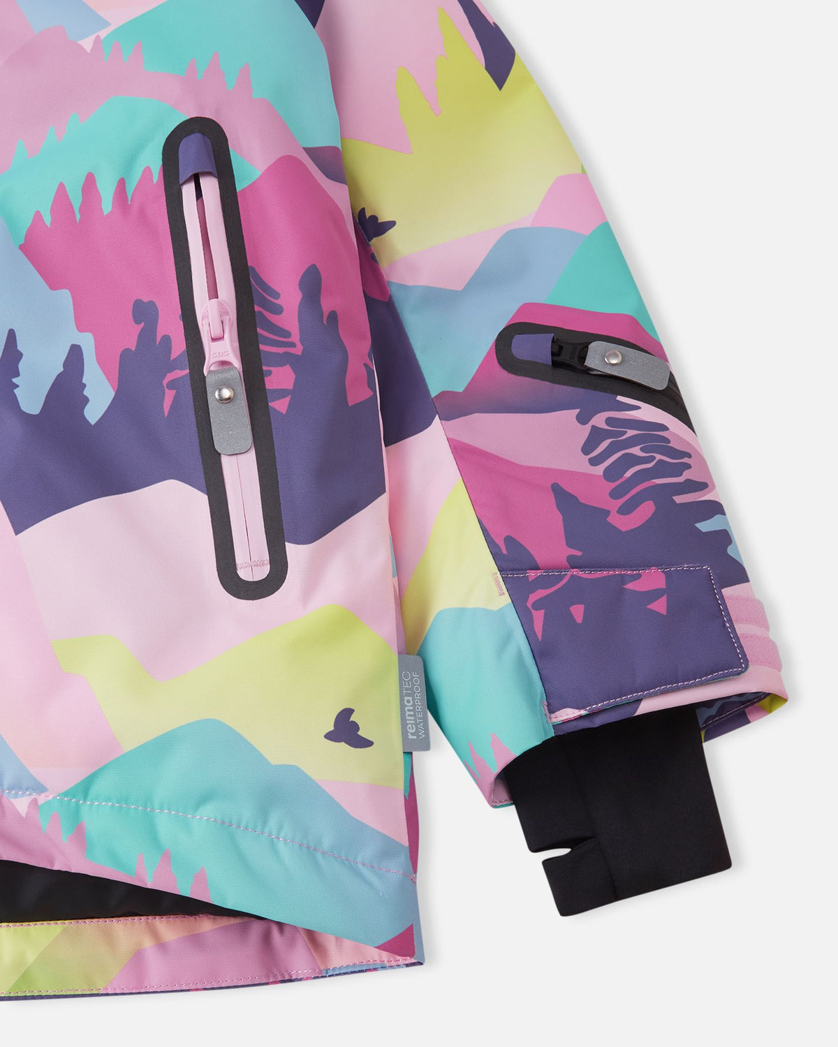 Close-up of the sleeve on the Reima Kiiruna girls' ski jacket, showing the adjustable Velcro outer cuff, black Lycra inner cuff with thumbhole, front zippered pocket, and the Reimatec waterproof authenticity tag.