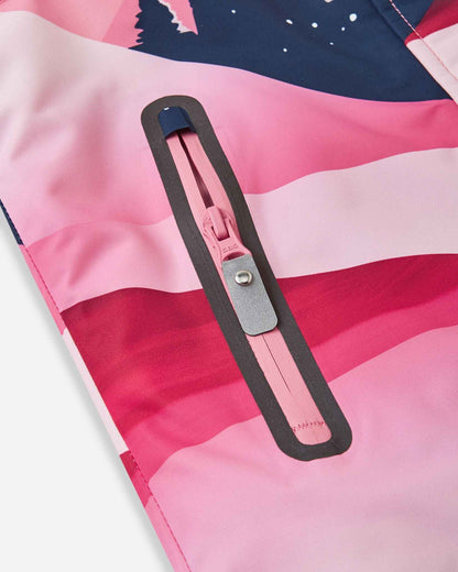 Detailed close-up of the water-repellent zippered pocket on the soft coral mountain print Reima Kiiruna girls' snow coat, highlighting the sealed pink zipper track and sturdy gray pull tab designed to keep small essentials perfectly dry on the slopes.