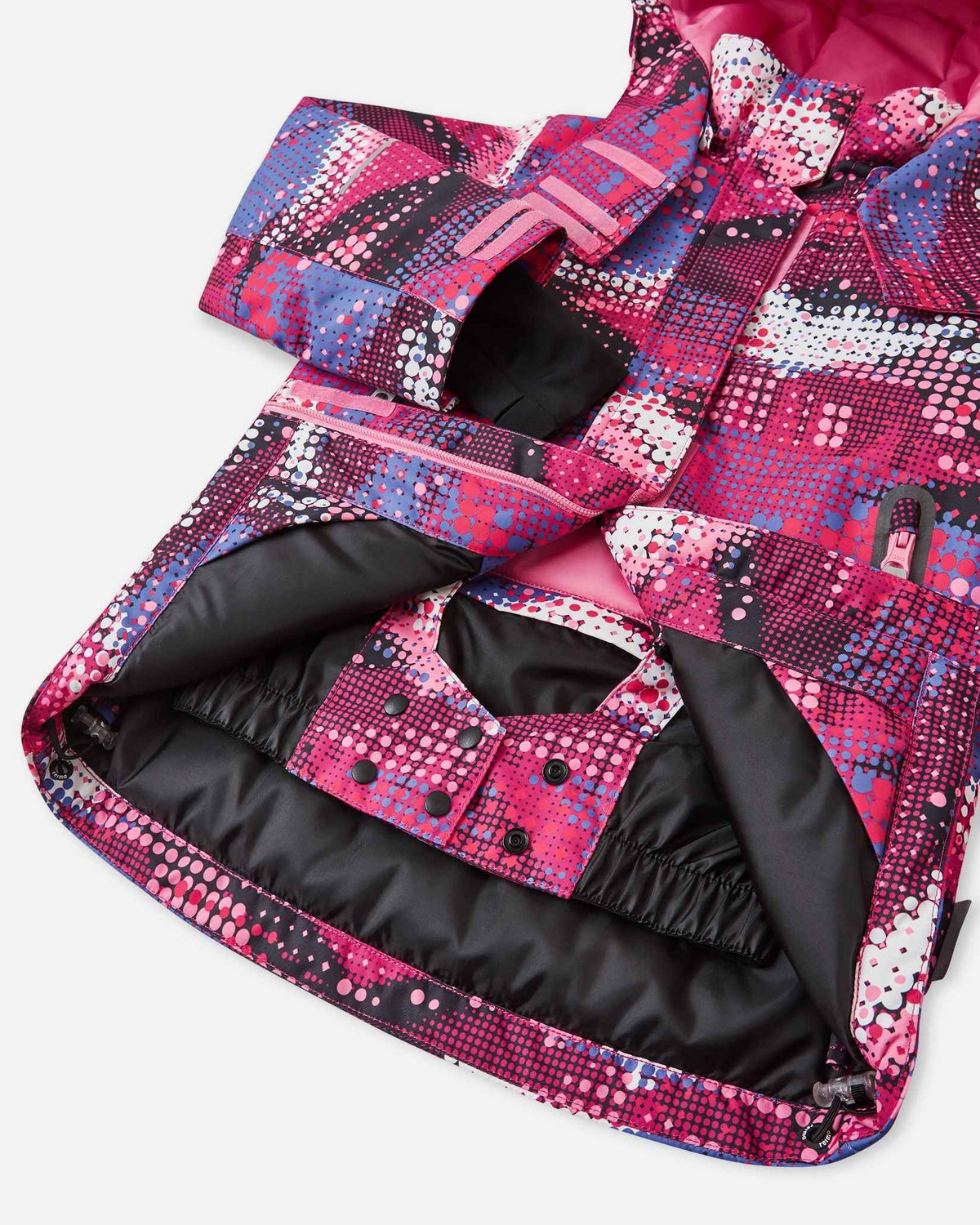 Open interior view of the lower hem on the rosy berry patterned Reima Kiiruna kids' snow coat, revealing the integrated snap-button powder skirt designed to completely seal out deep snow during alpine skiing and winter play.