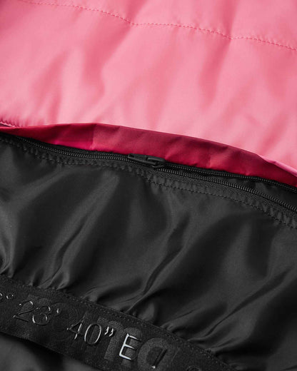 Close-up of the durable zip-in snow skirt attachment on the inside lining of the soft coral Reima Kiiruna kids' winter jacket, engineered to prevent powder snow from riding up during alpine skiing.