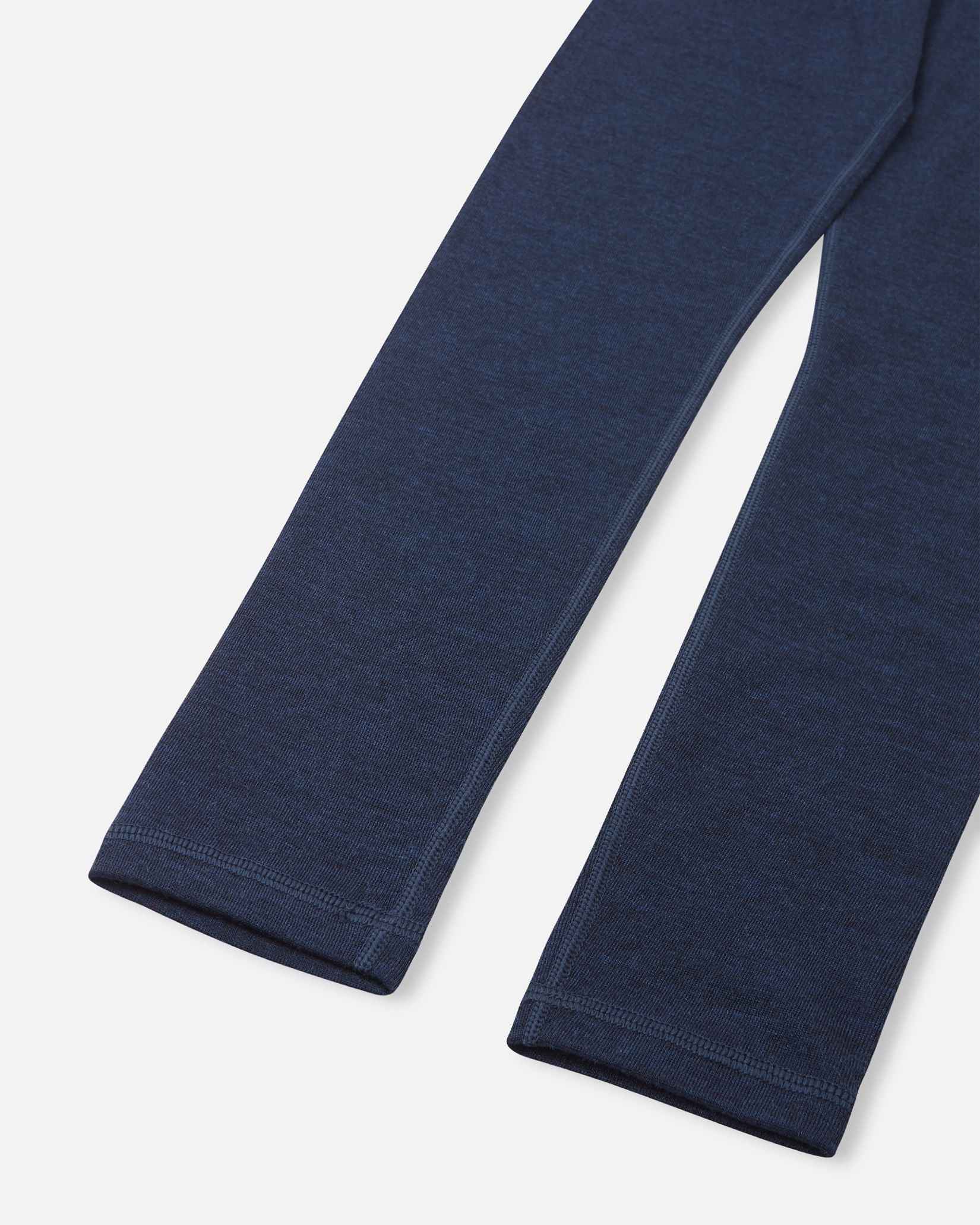 Detailed close-up of the bottom cuffs of the navy blue merino wool base layer leggings from the Reima Kinsei set, showing the precision stitching and fabric texture.