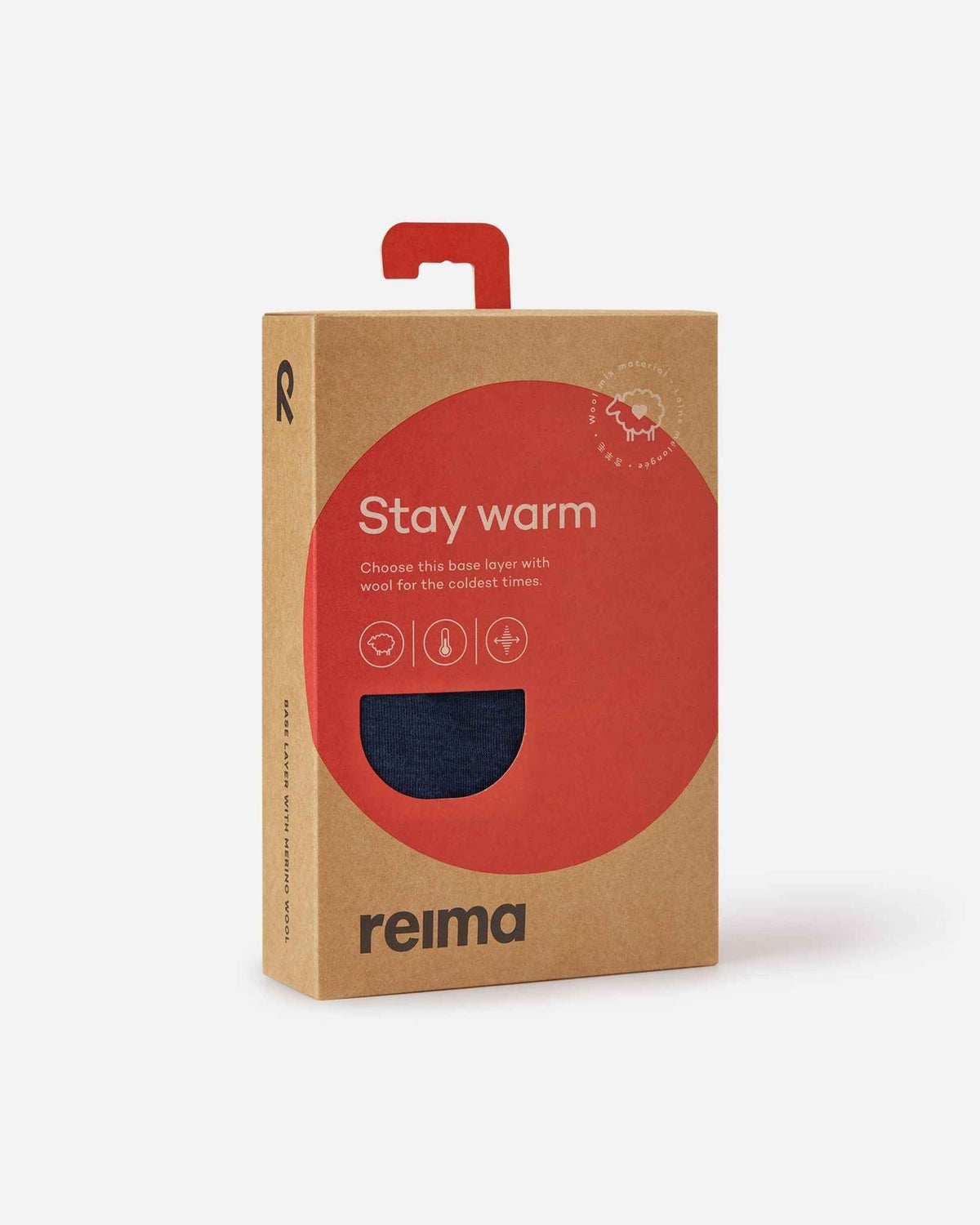 Front view of the brown retail cardboard box for the Reima Kinsei kids merino wool base layer set, featuring a red 'Stay warm' label and a circular cutout displaying the navy blue fabric.