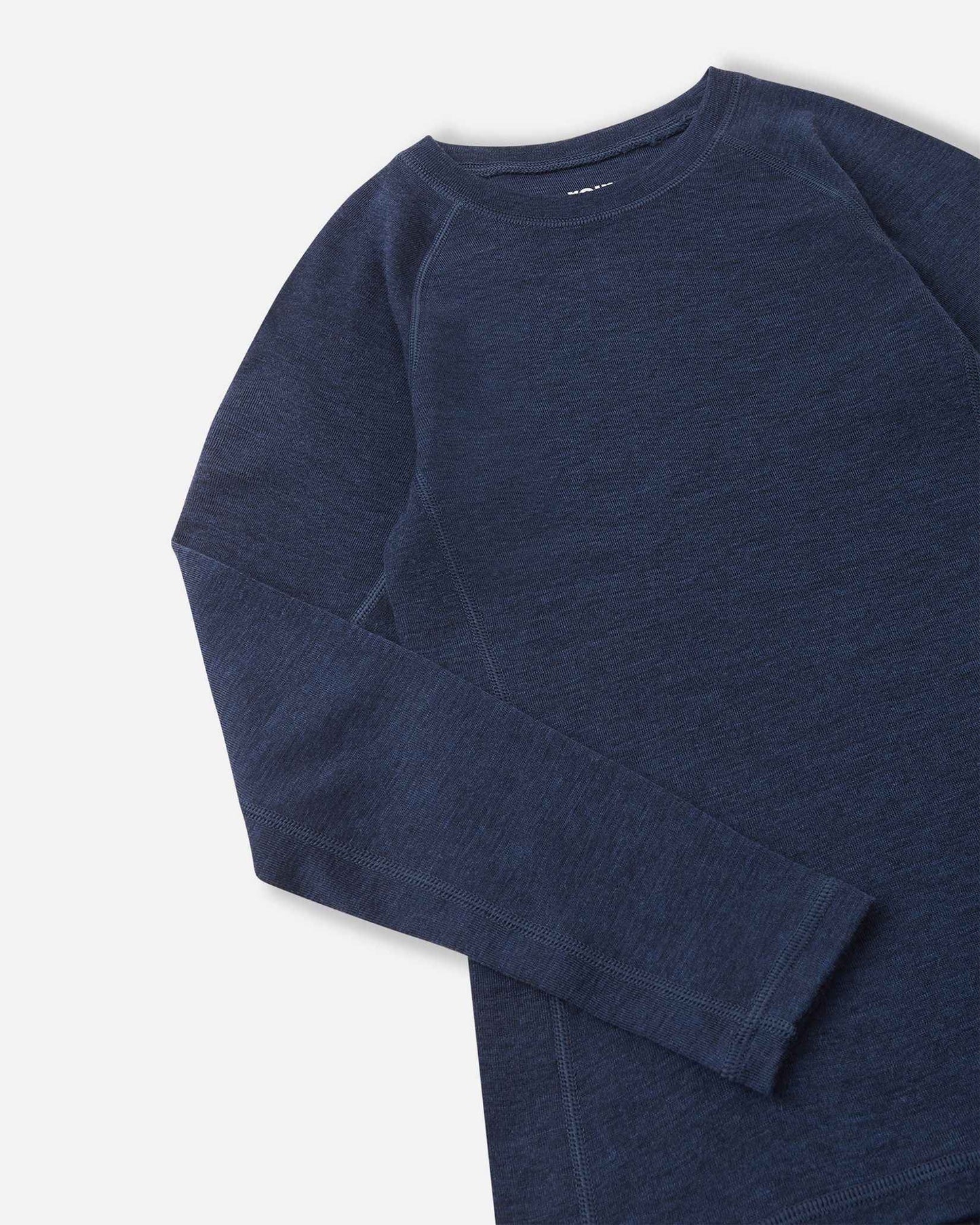 Detailed close-up shot of the navy blue merino wool base layer top from the Reima Kinsei set, showing the texture of the fabric, flat-lock stitching on the shoulder, and sleeve cuff.