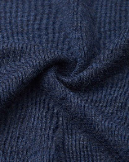 Detailed macro close-up of the navy blue knitted merino wool fabric used in the Reima Kinsei kids base layer set, swirled to display its soft texture.