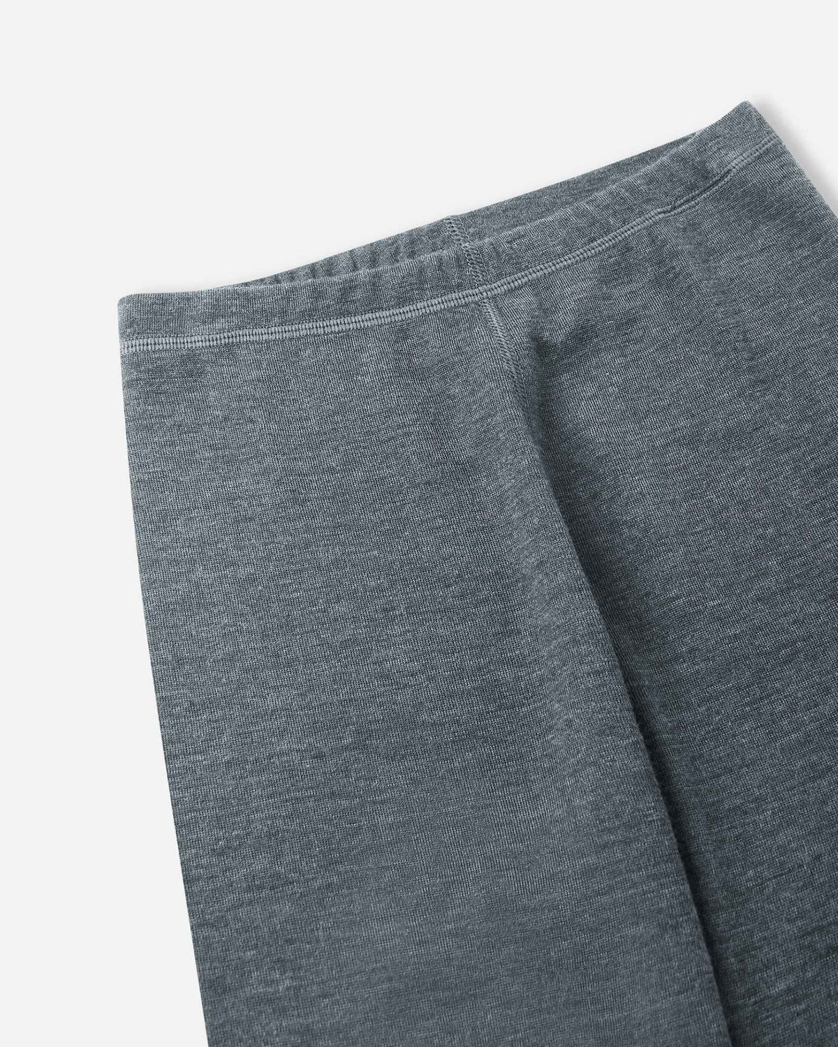 Close-up of the comfortable elastic waistband and soft knit fabric on the Reima Kinsei kids' merino wool base layer pants in melange grey.
