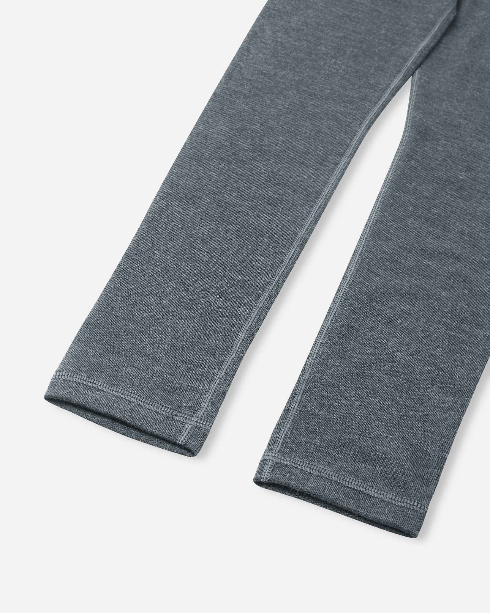 Close-up of the pant legs on the Reima Kinsei kids' merino wool base layer bottoms in melange grey, highlighting the comfortable flat seams.
