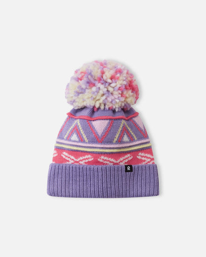 Alternate front flat lay view of the blooming lilac Reima Kirjoen children's jacquard knit winter hat. The image showcases the premium merino wool-blend texture, the small woven black Reima logo tag on the hem, and the fun geometric winter design.