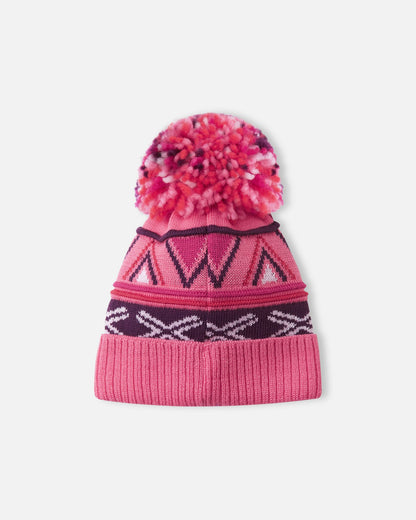 Back flat lay view of the soft coral pink Reima Kirjoen kids' merino wool beanie, displaying the continuous seamless geometric jacquard knit pattern and the cozy, colorful yarn pom-pom designed to retain body heat in cold weather.
