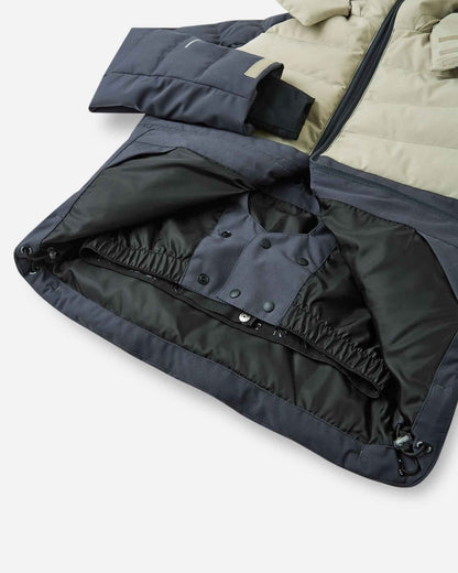 Interior view of the Reima Kuosku kids ski jacket in Soft black, highlighting the built-in snap-button snow skirt designed to keep powder out during winter sports.