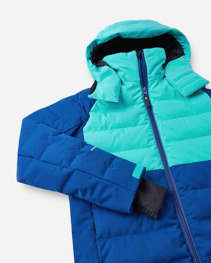 Close-up of the upper half of the Reima Kuosku kids ski jacket in twilight blue, detailing the high protective collar, main front zipper, and adjustable velcro cuffs with inner lycra thumbhole sleeves.
