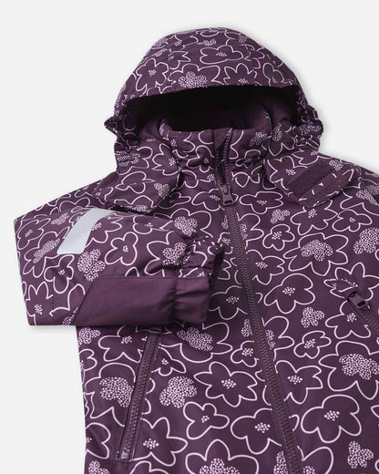 Close-up on the chest and hood of the deep purple Reima Kurikka winter suit, emphasizing the smooth center zipper, protective storm flap, and the charming white flower outline pattern.