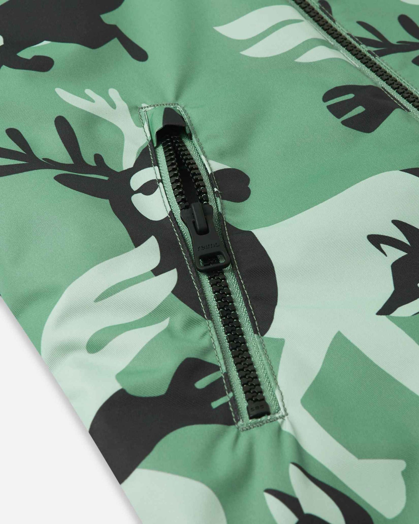 Close-up of the secure zippered pocket on the chest of the green clay Reima Kurikka winter suit, surrounded by a forest animal pattern.