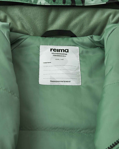 Inside label of the Reima Kurikka kids snowsuit displaying the Reima weatherproofing branding and a writable space for the child's name.