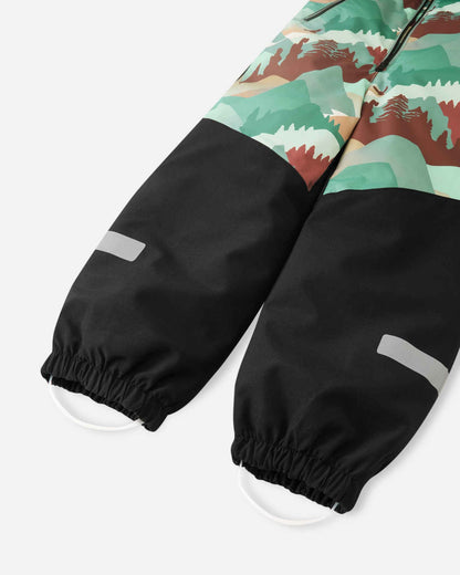 Detail shot of the lower legs on the Reima Kurikka kids' snowsuit, featuring the durable black reinforced fabric, elastic ankle cuffs, reflective safety strips, and silicone foot loops.
