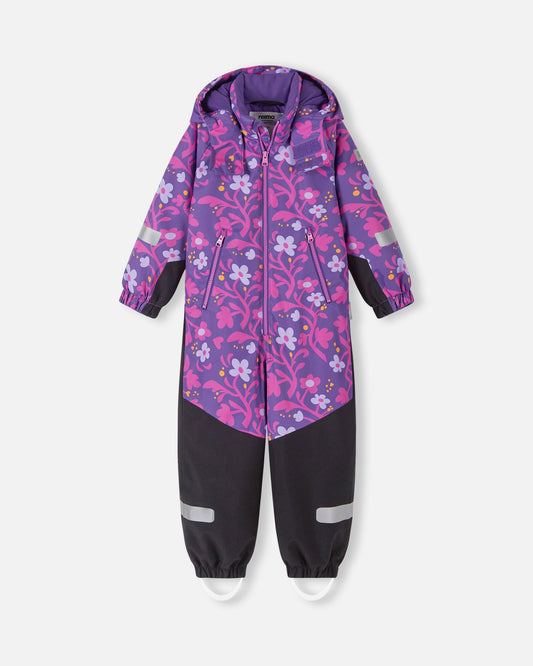 Front view of the Reima Kurikka waterproof kids' snowsuit in plum purple, featuring a bright floral pattern on the top half and durable, solid black reinforced fabric from the waist down to protect against winter wear.