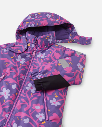 Close-up of the Reima Kurikka kids' snowsuit showcasing the safe, snap-button detachable hood partially undone, alongside the elastic sleeve cuff featuring black reinforced fabric for extra durability.