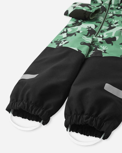 Bottom half of the Reima Kurikka snowsuit showing heavy-duty black reinforced leg cuffs, silicone foot loops, and reflective safety bands.