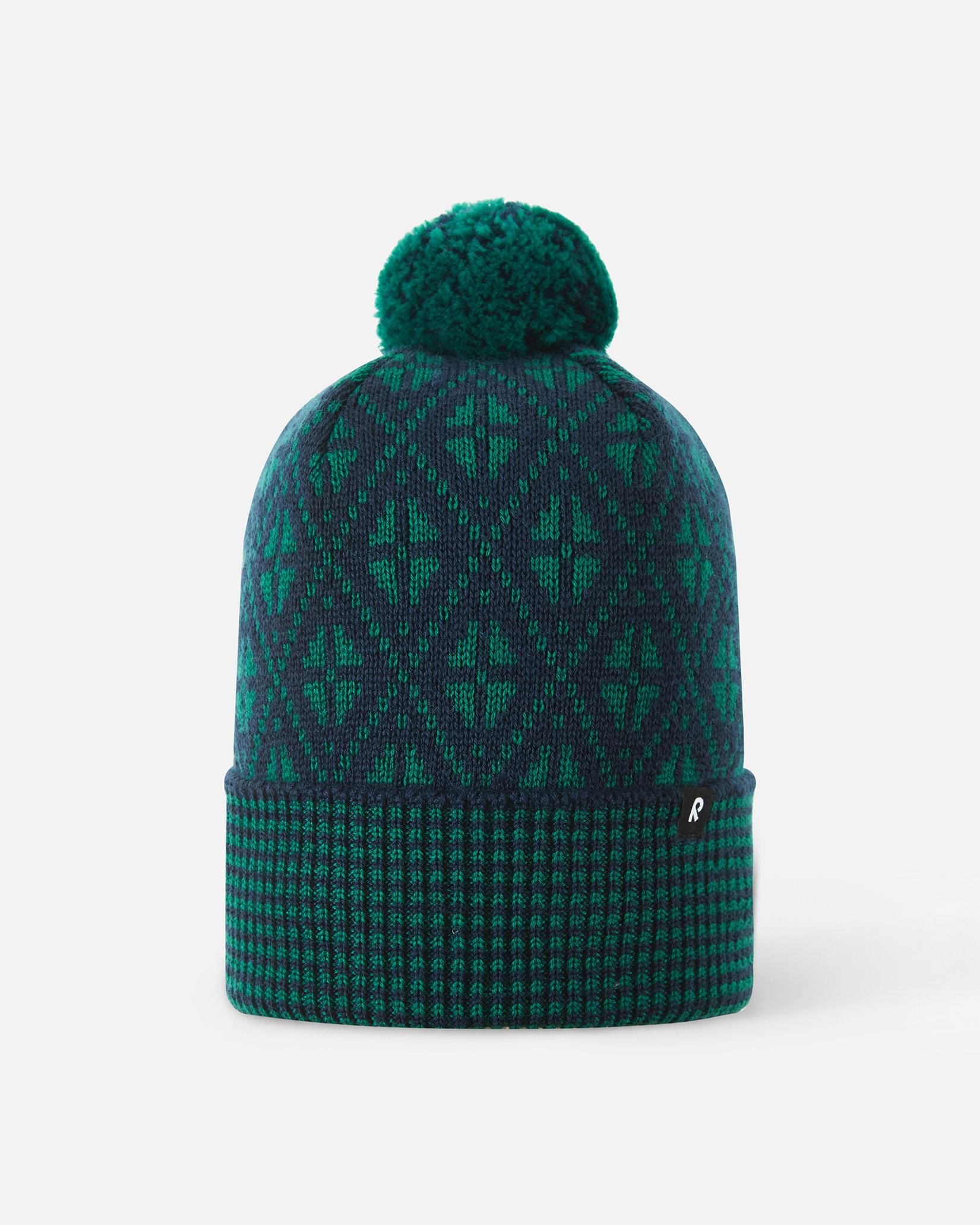 Front view of the Reima Kuurassa kids' merino wool beanie hat in navy blue with green accents, featuring a Nordic-inspired geometric pattern, a ribbed fold-over brim, and a matching pom-pom.