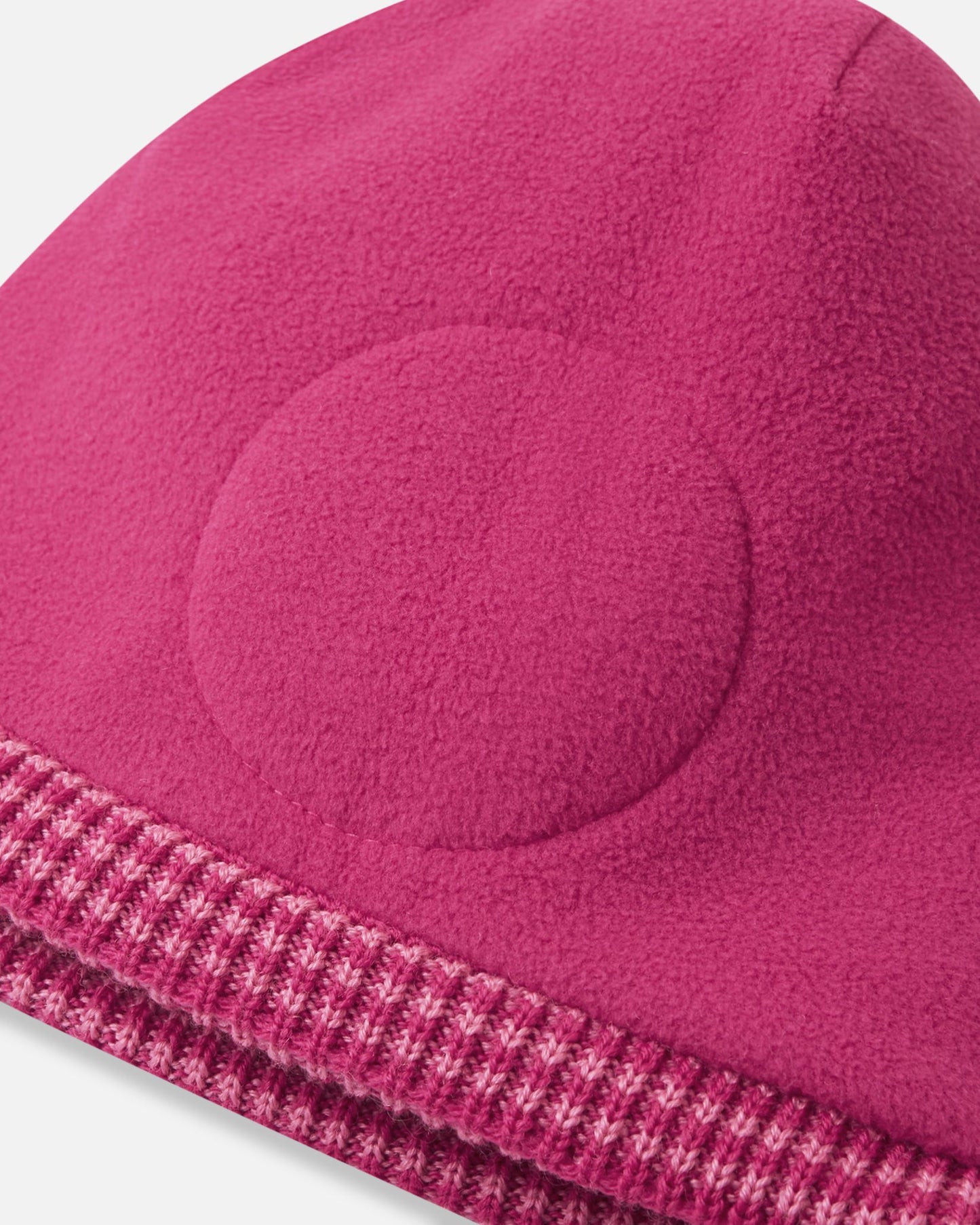 Close-up inside detail of the rosy berry Reima Kuurassa kids' wool beanie, showing the soft fleece inner lining and the built-in circular windproof earpieces designed to protect little ears from harsh winter winds.