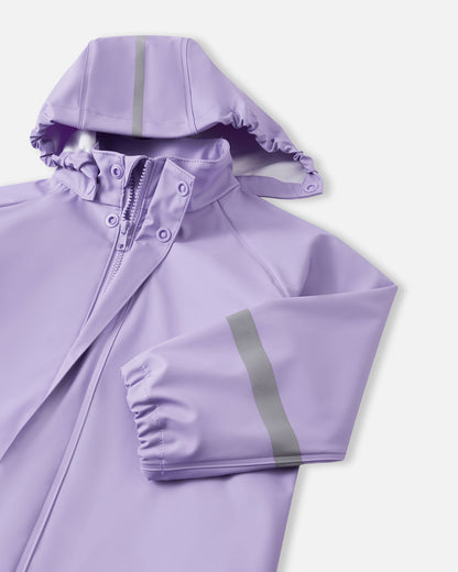 Detailed angled front view of the Reima Lampi blooming lilac raincoat collar, highlighting the smooth front zipper tucked safely under a snap-button storm flap, and a wind-resistant elasticized hood featuring a prominent high-visibility reflective safety stripe.
