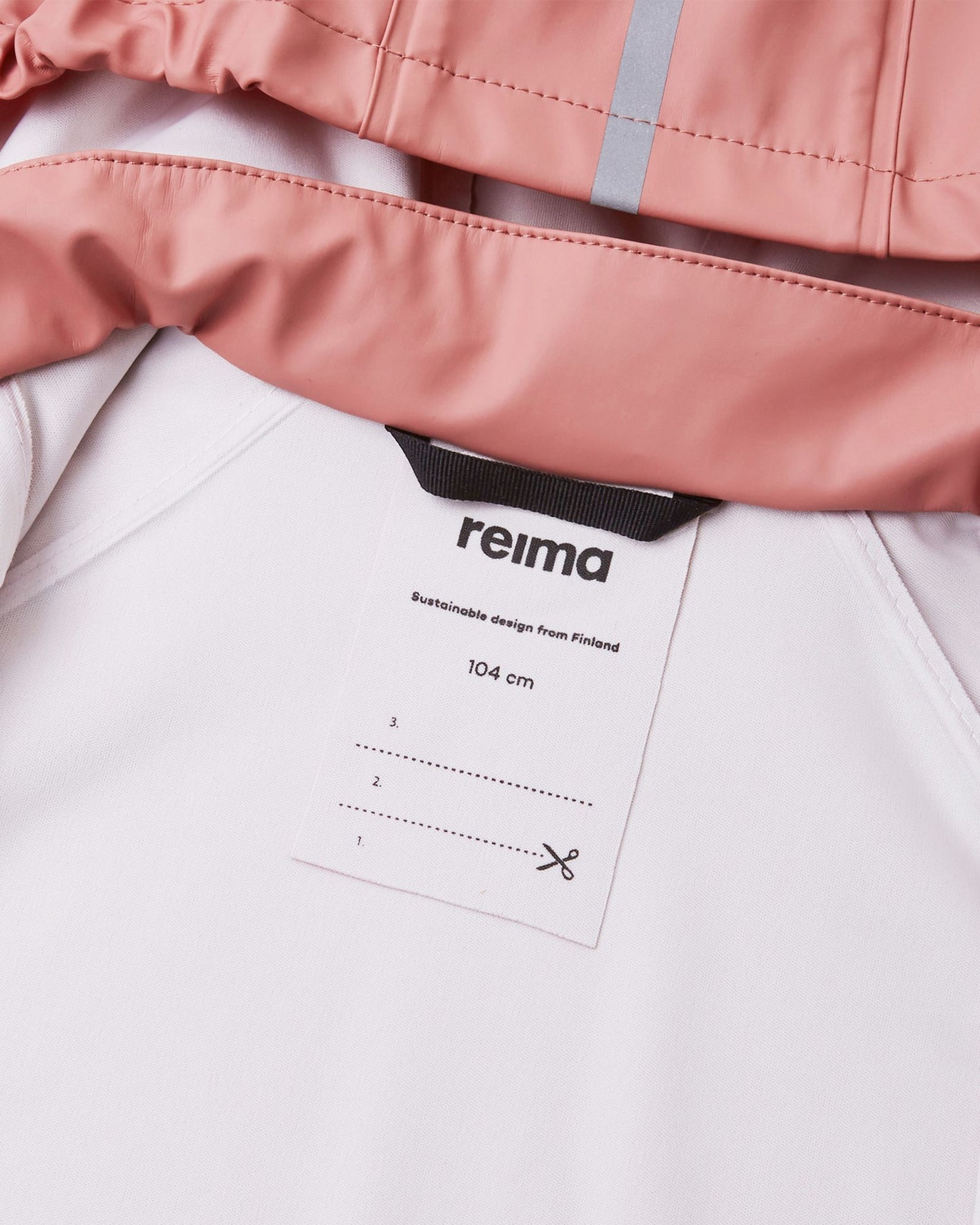 Close-up view of the interior collar on the Reima Lampi rose blush raincoat, displaying a durable black hanging loop and a built-in customizable name tag with writing lines to easily identify the jacket at school or daycare.