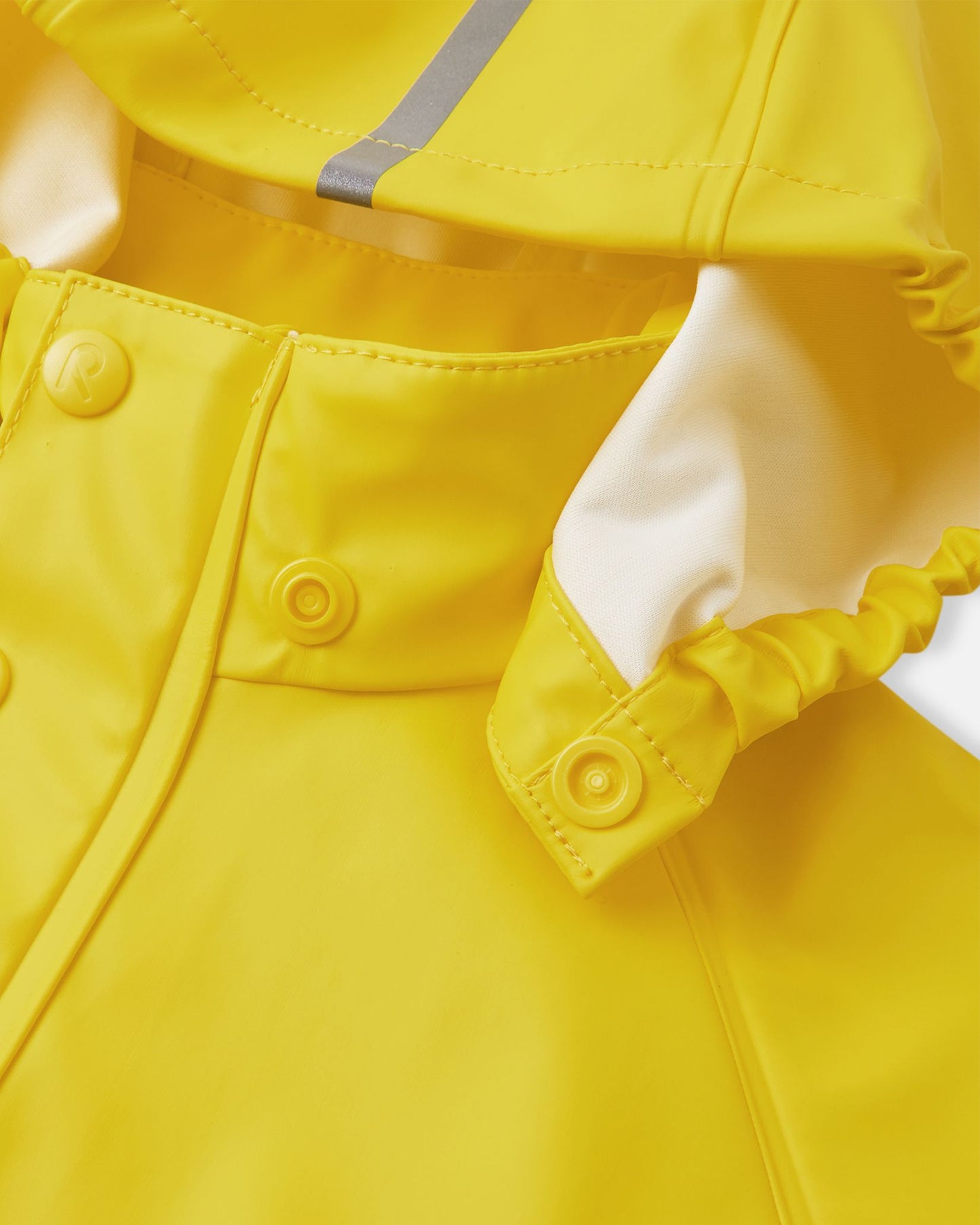 Detail shot of the Reima Lampi raincoat collar, highlighting the child-safe snap buttons that allow the yellow hood to detach easily and safely if it gets caught on tree branches during outdoor play.