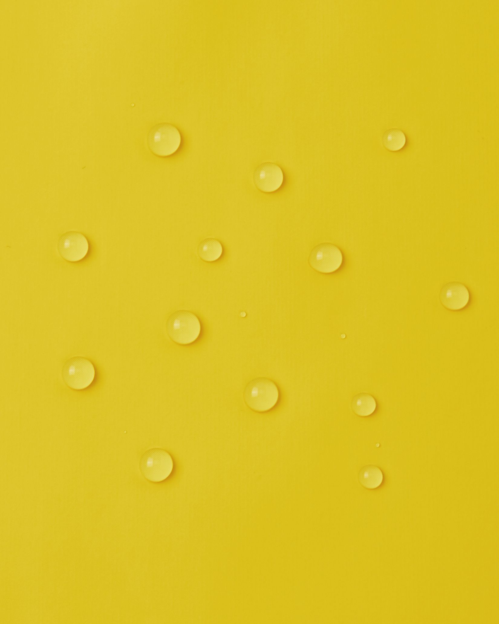 Macro close-up of water droplets perfectly beading on the smooth, bright yellow waterproof polyurethane surface of the Reima Lampi raincoat, demonstrating its excellent ability to repel rain and keep kids completely dry.