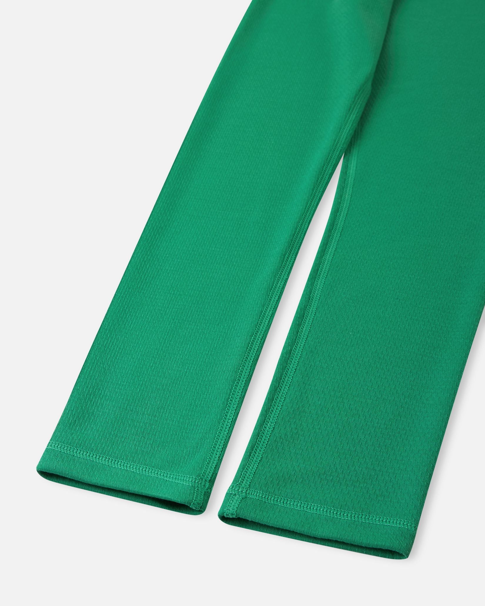Close-up of the ankle cuffs and flatlock seams on the green Reima Lani kids' thermal base layer pants, built to prevent chafing during active play.