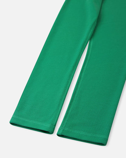 Close-up of the ankle cuffs and flatlock seams on the green Reima Lani kids' thermal base layer pants, built to prevent chafing during active play.
