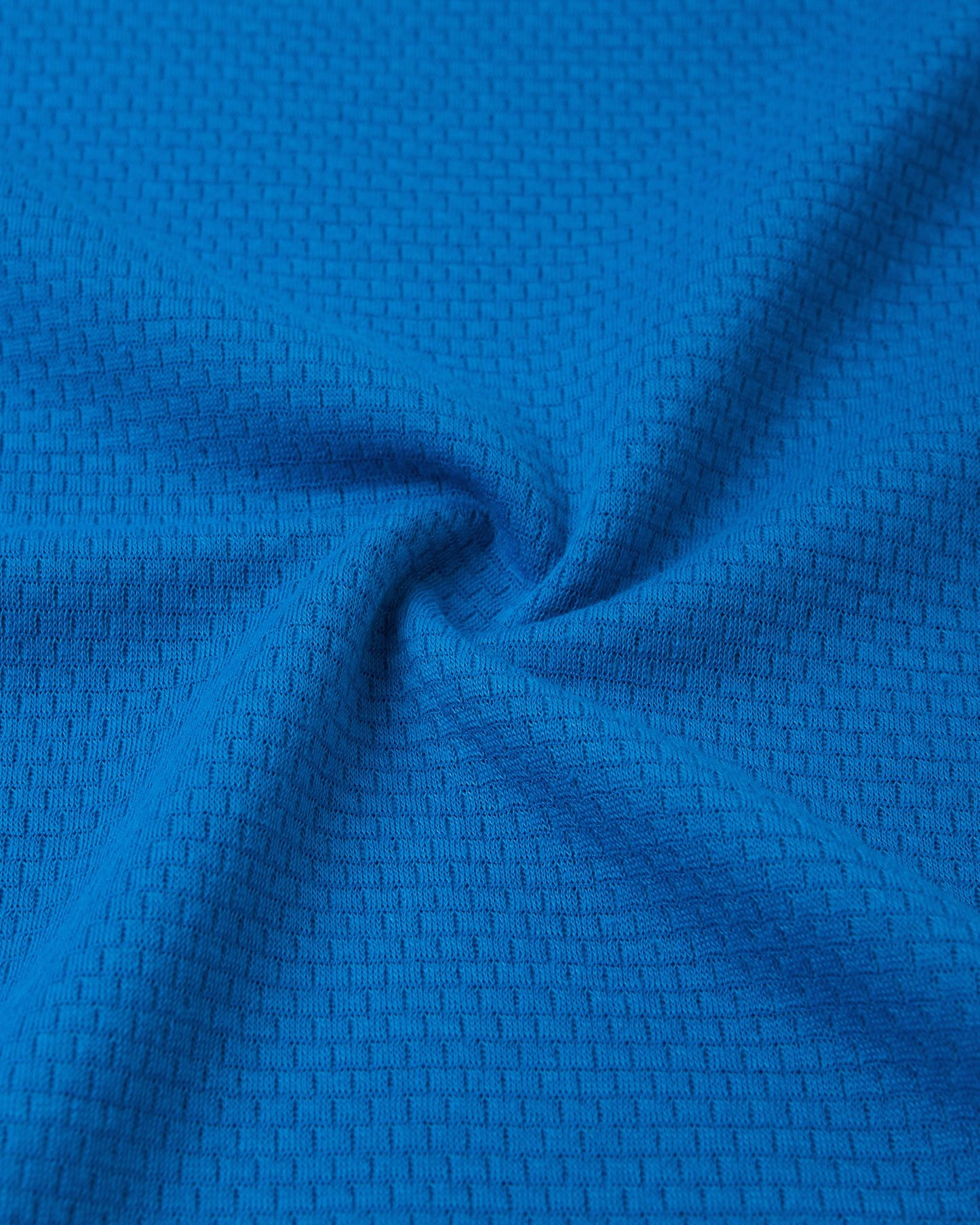 Close-up texture view of the soft, insulating Thermolite material used in the bright blue Reima Lani kids' base layer set, designed for superior temperature regulation.