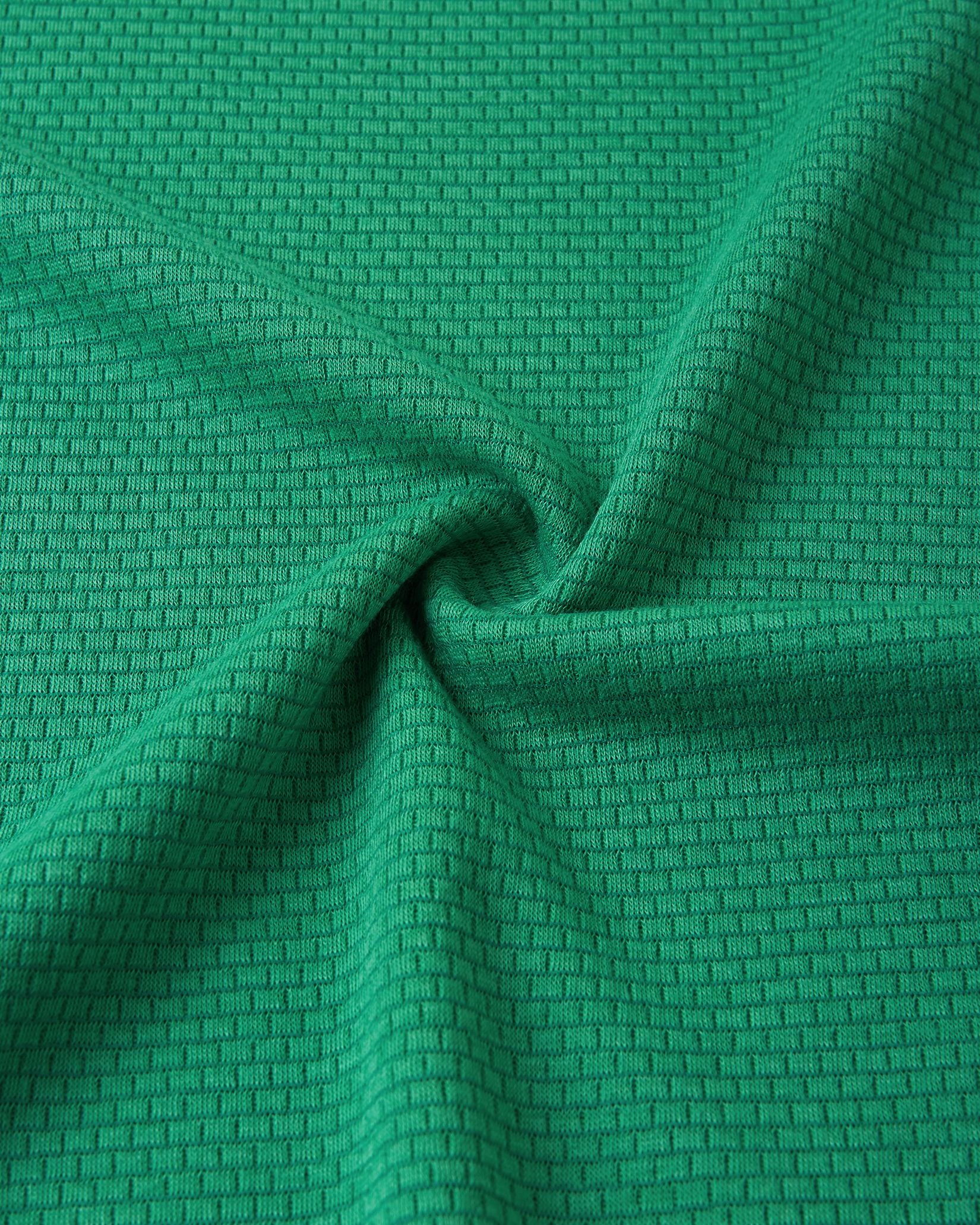 Close-up texture view of the soft, insulating Thermolite material used in the green Reima Lani kids' base layer set, designed for superior temperature regulation.