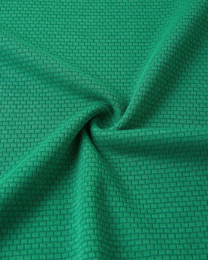 Close-up texture view of the soft, insulating Thermolite material used in the green Reima Lani kids' base layer set, designed for superior temperature regulation.