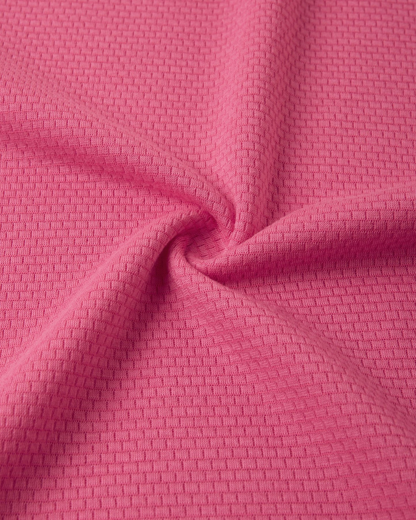 Close-up texture view of the soft, insulating Thermolite material used in the soft coral Reima Lani kids' base layer set for superior warmth and breathability.