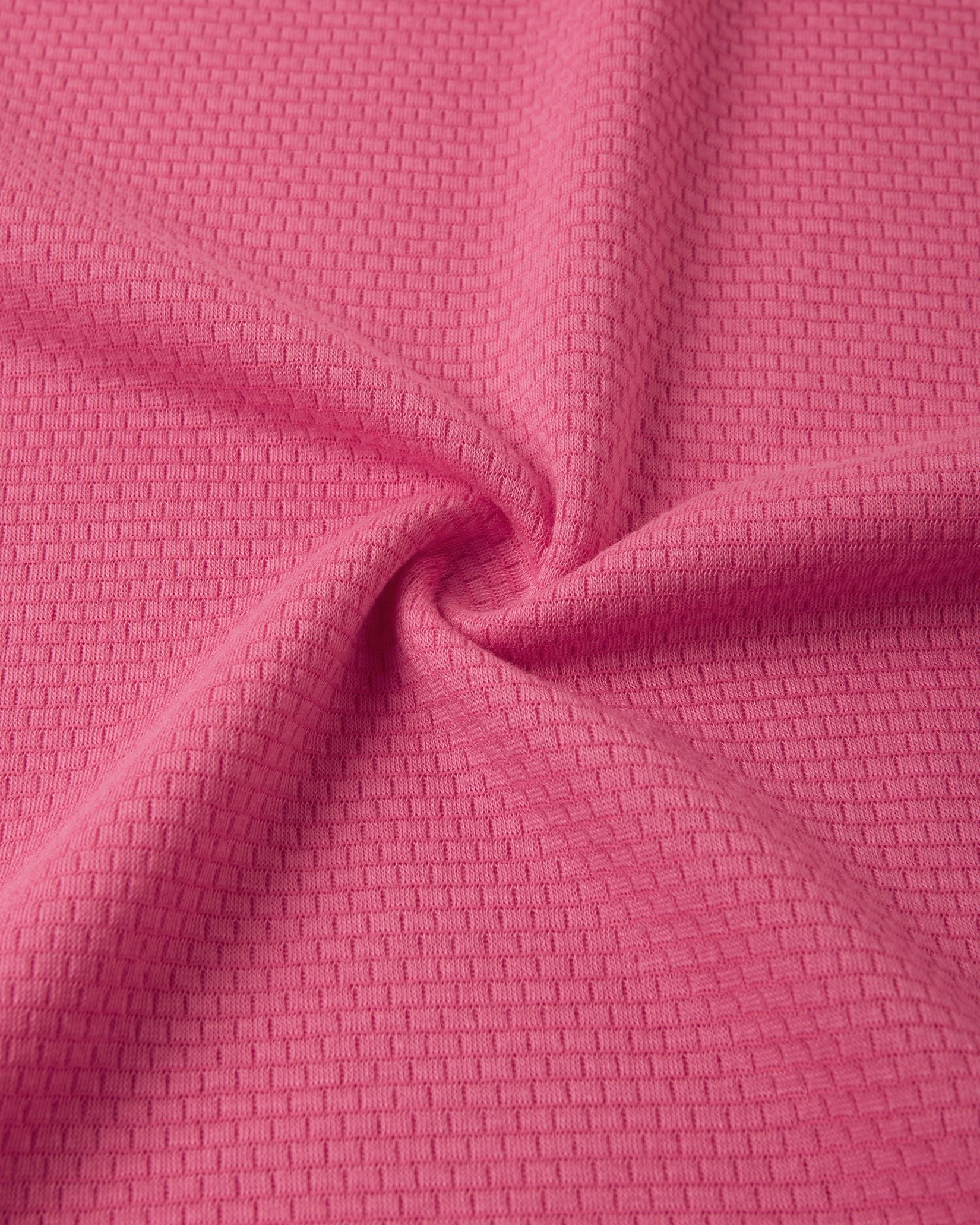 Close-up texture view of the soft, insulating Thermolite material used in the soft coral Reima Lani kids' base layer set for superior warmth and breathability.