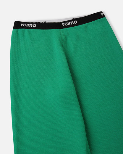 Detailed view of the soft elastic waistband featuring the Reima logo on the green Lani kids' thermal base layer bottoms.