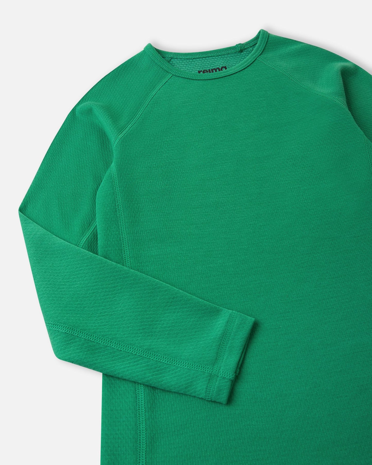 Close-up detail of the crew neck collar and raglan sleeve stitching on the green Reima Lani kids' moisture-wicking thermal shirt.