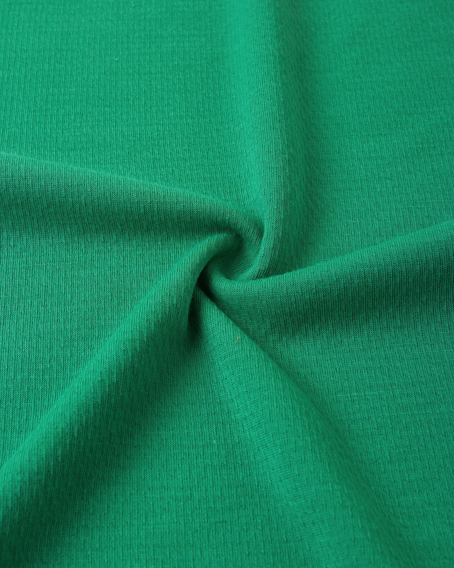Macro close-up of the technical knit fabric on the green Reima Lani kids' Thermolite base layer, highlighting its moisture-wicking grid texture.