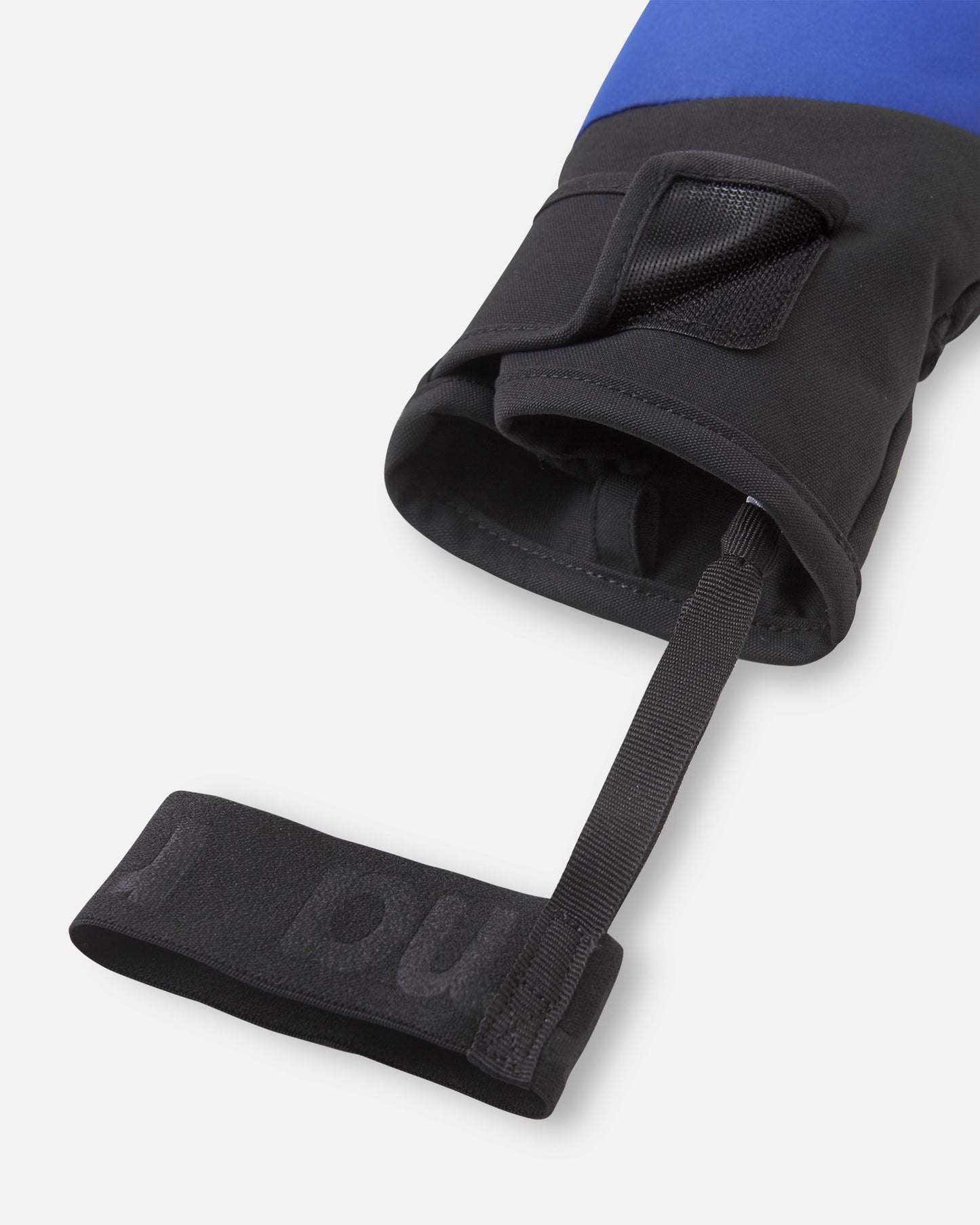 Close-up detail of the cuff opening on the twilight blue Reima Lapases kids' ski mittens, highlighting the wide hook-and-loop adjustment tab and the attached elastic safety wrist leash to keep gear securely in place.