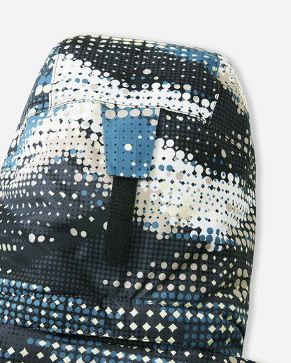 Close-up of the back of the hood on the Reima Lappea kids' ski suit in a soft black, blue, and cream geometric pattern, highlighting the durable velcro adjustment strap that allows parents to customize the fit for safety and helmet compatibility.