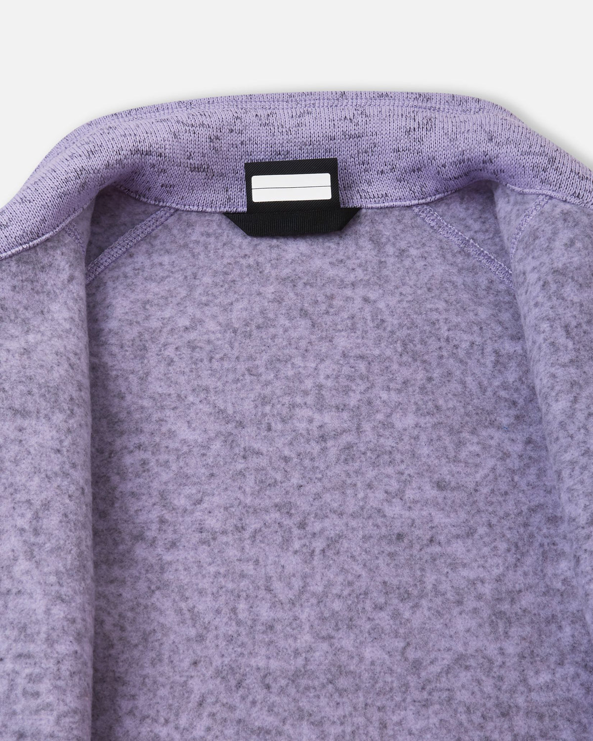 Detail view of the inner neck label on the blooming lilac Reima Laskien kids' fleece jacket, providing space for a name tag and showcasing the soft, warm fleece lining.