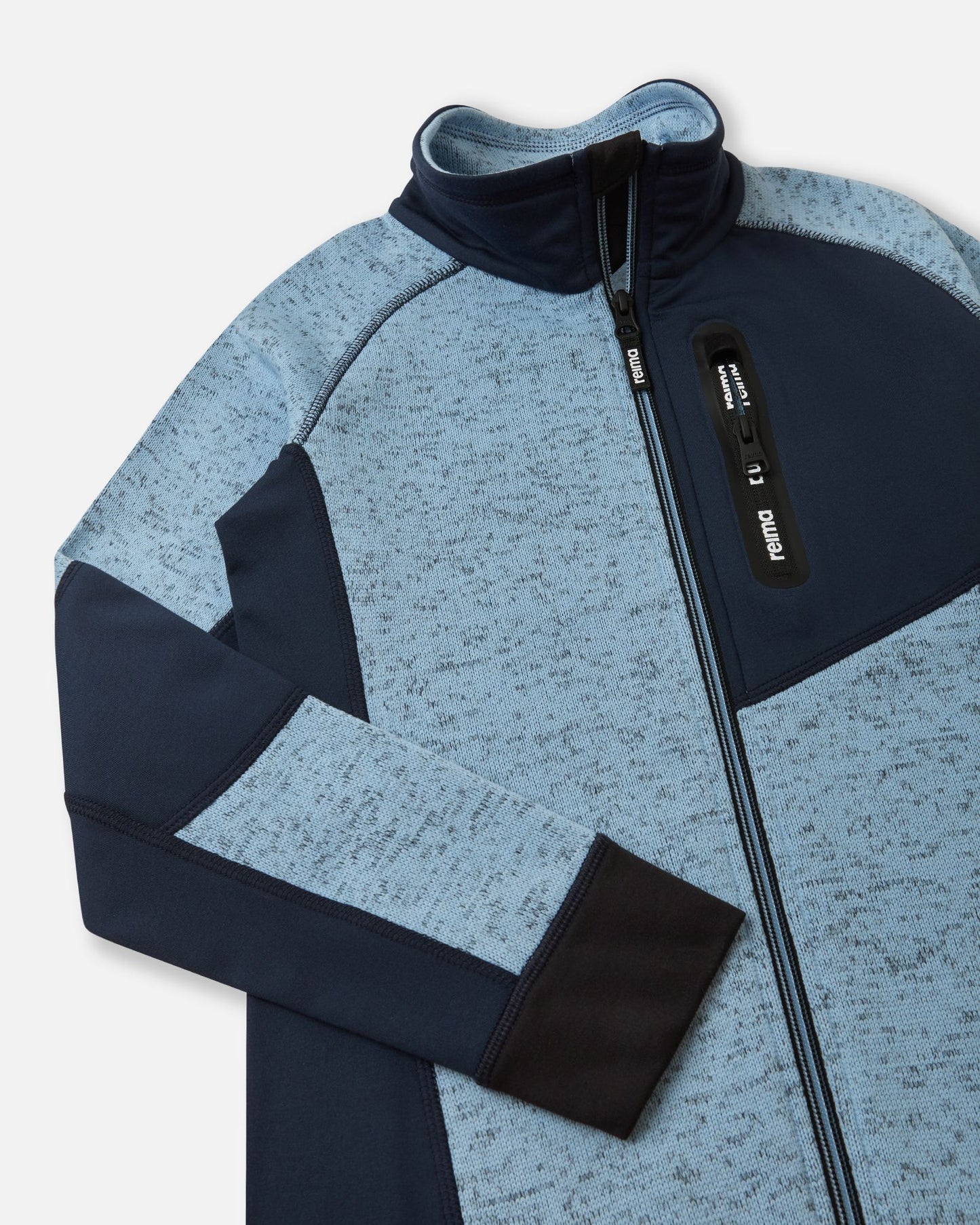 Close-up of the secure zippered chest pocket on the frozen blue Reima Laskien kids' fleece jacket, featuring a black zipper pull and reinforced trim.