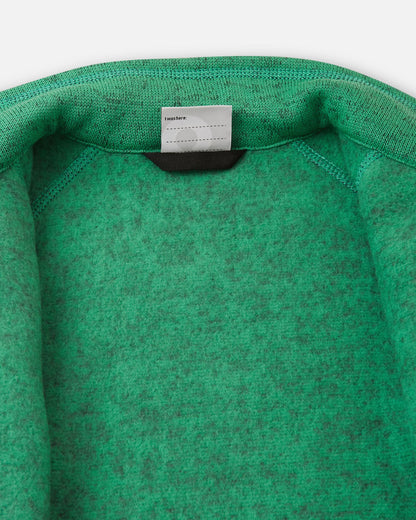 Inside collar view of the green Reima Liukuen kids' fleece jacket, displaying the soft brushed fleece interior for thermal comfort and a customizable name tag.