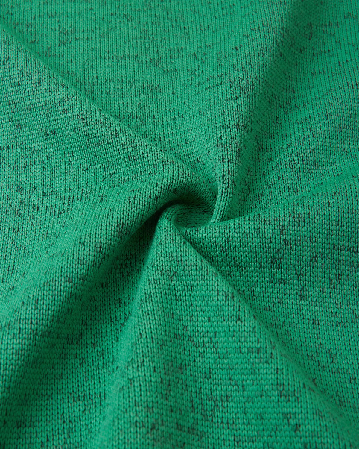 Macro fabric texture of the green Reima Liukuen kids' fleece jacket, highlighting the durable, sweater-knit exterior designed for active warmth.