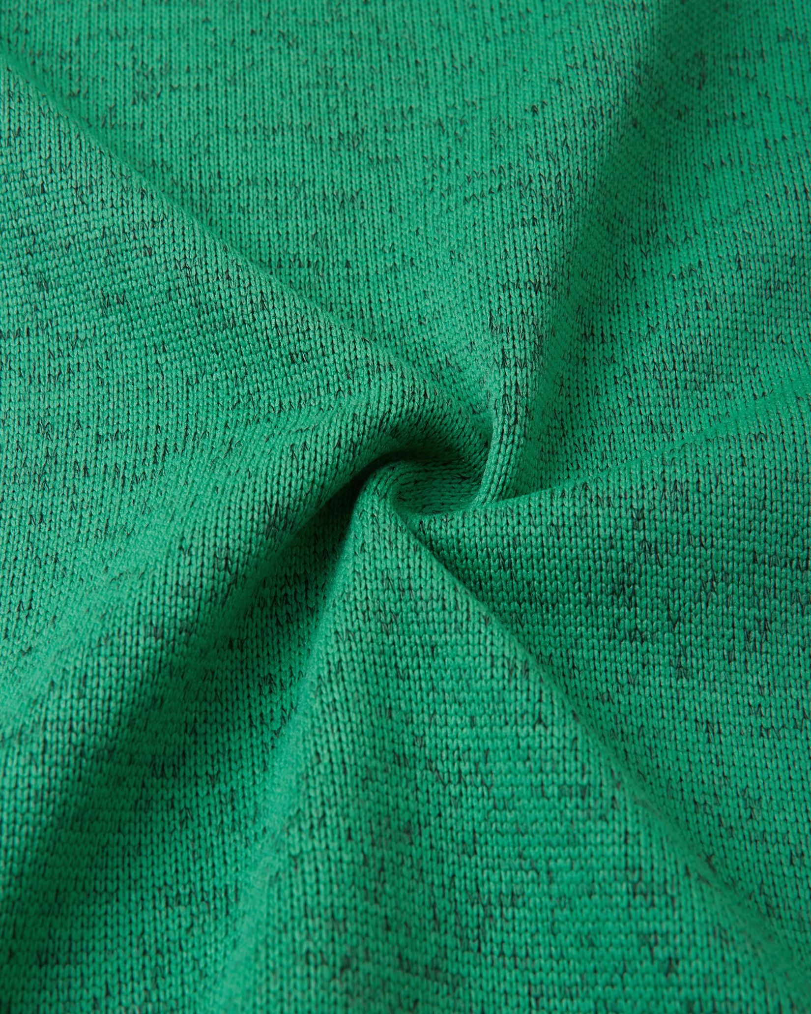 Macro fabric texture of the green Reima Liukuen kids' fleece jacket, highlighting the durable, sweater-knit exterior designed for active warmth.