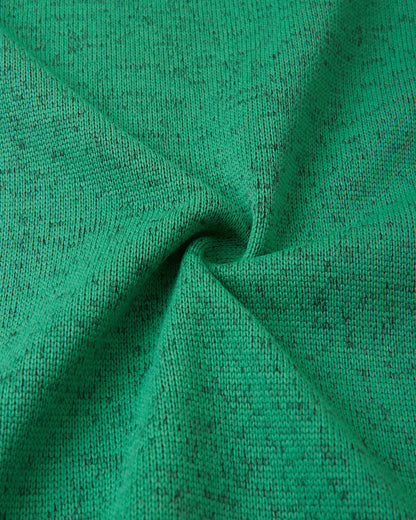 Macro fabric texture of the green Reima Liukuen kids' fleece jacket, highlighting the durable, sweater-knit exterior designed for active warmth.