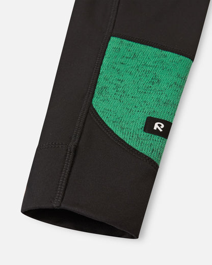 Close-up of the reinforced black sleeve cuff on the green Reima Liukuen kids' fleece jacket, showing durable stitching and the reflective Reima logo tab.