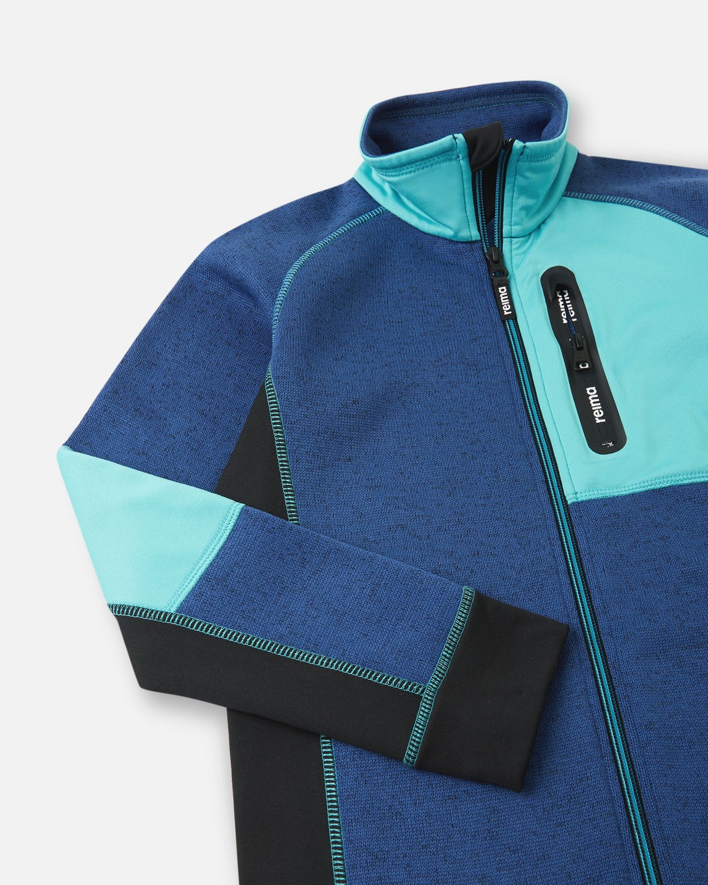 Close-up of the cyan blue zippered chest pocket on the twilight blue Reima Liukuen kids' fleece jacket, featuring a protective high collar and anti-chafe chin guard.
