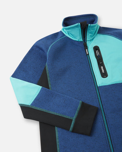 Close-up of the cyan blue zippered chest pocket on the twilight blue Reima Liukuen kids' fleece jacket, featuring a protective high collar and anti-chafe chin guard.